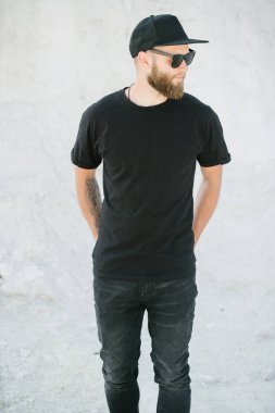 Hippi, sakallı, siyah, boş tişörtlü, logonuz için yeri olan yakışıklı bir erkek model.