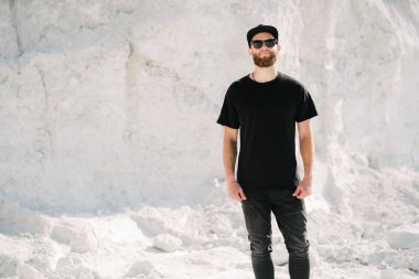 Hippi, sakallı, siyah, boş tişörtlü, logonuz için yeri olan yakışıklı bir erkek model.