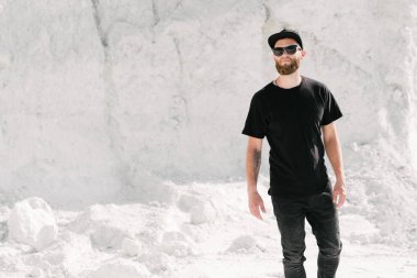 Hippi, sakallı, siyah, boş tişörtlü, logonuz için yeri olan yakışıklı bir erkek model.