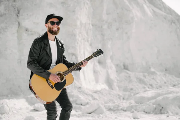 Guitar player singing outside. Hipster guitar player with beard and black clothes — Stock Photo, Image