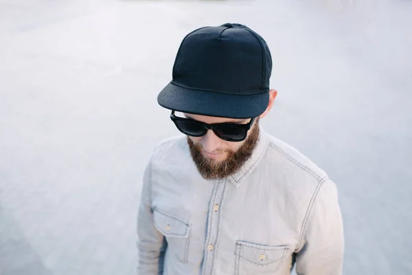 Hipster tampan model pria dengan jenggot mengenakan topi baseball kosong hitam dengan ruang untuk logo Anda — Stok Foto