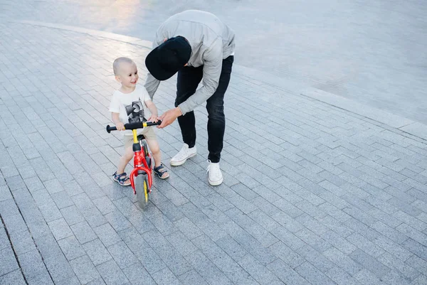 Отец учит сына кататься на велосипеде — стоковое фото