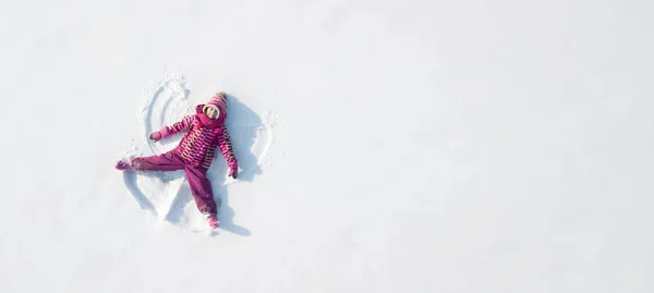 Kind bastelt einen Schneengel. Blick von oben — Stockfoto