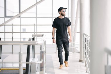 Hippi, sakallı, siyah, boş tişörtlü, logonuz için yeri olan yakışıklı bir erkek model.