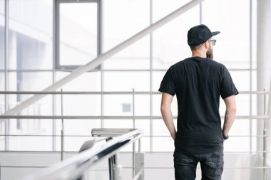 Hippi, sakallı, siyah, boş tişörtlü, logonuz için yeri olan yakışıklı bir erkek model.