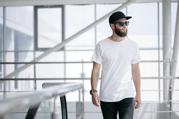 Hipster jóképű férfi modell szakáll visel fehér üres póló és egy baseball sapka helyet a logó vagy design alkalmi városi stílusban — Stock Fotó