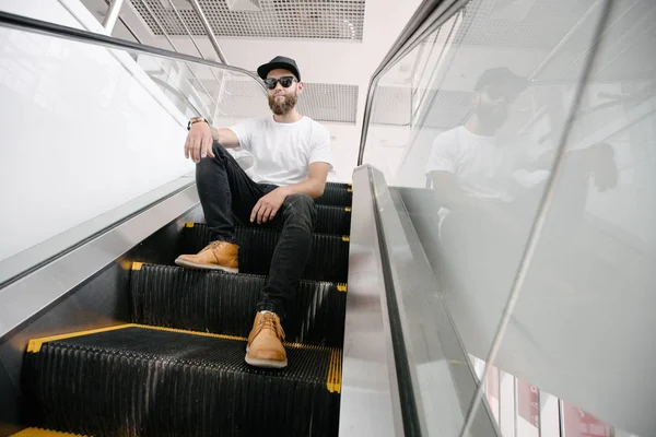 Retrato de um homem Hipster com a barba de perto. Ele está parado num escaparina. — Fotografia de Stock