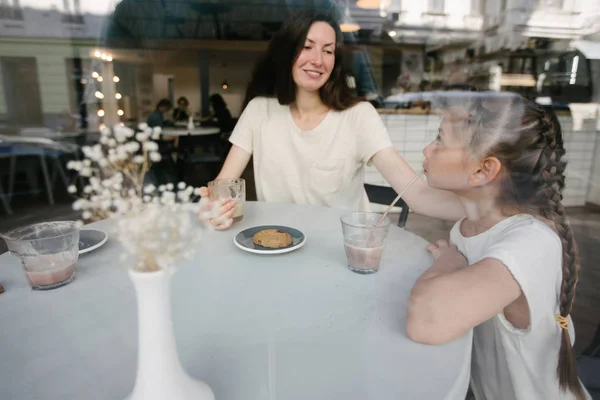 Anya gyermekek forró csokoládét és latte a helyi kávézóban. Mosolyognak, és a szórakozás. — Stock Fotó