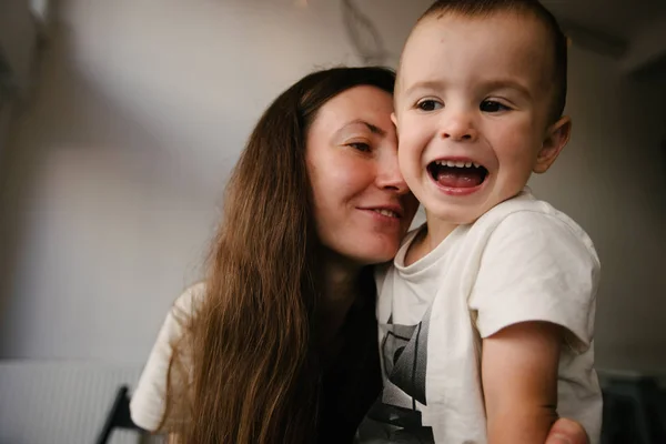 Мать и маленький сын обнимаются и улыбаются — стоковое фото