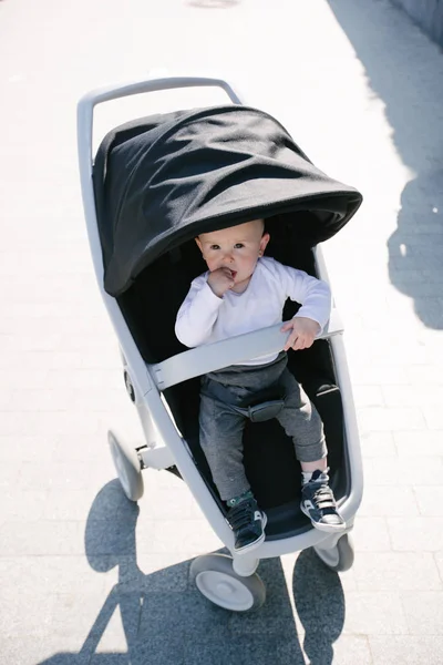 Baby in de straten van de stad zittend in een kinderwagen — Stockfoto