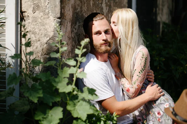 Blonde girl and Hipster handsome man with beard hugging and kissing on the city streets — Stock Photo, Image