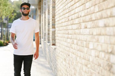 Sakallı, beyaz, boş tişörtlü, beysbol şapkalı, logonuz için yeri olan yakışıklı bir hippi mankeni.