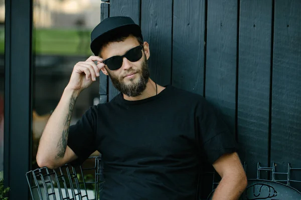 Elegante hombre guapo con gafas de sol y sonriendo — Foto de Stock