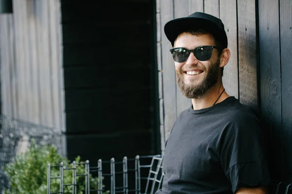 Elegante homem bonito vestindo óculos de sol e sorrindo — Fotografia de Stock