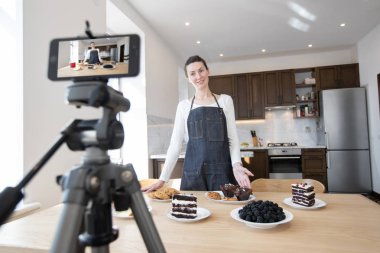 Kadın vlogger yemek kanalı için video kayıt. Cooker shef bir telefon ile vlog için bir video kayıt