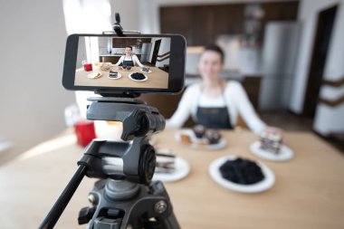 Kadın vlogger yemek kanalı için video kayıt. Cooker shef bir telefon ile vlog için bir video kayıt