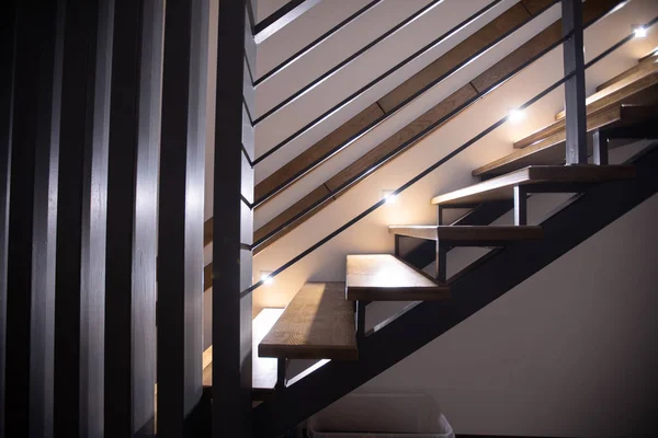Dřevěné schodiště v interiérech domu se světlem schodiště — Stock fotografie