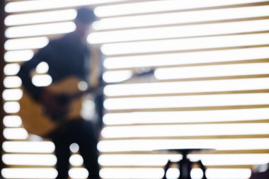 Şarkıcı ve gitarist neon ışıkları ile bir sahnede şarkı. O bir rockçı ve o deri bisikletçi ceket veya siyah kap, kot pantolon ile asimetrik zip ceket giyiyor. Bulanık görüntü