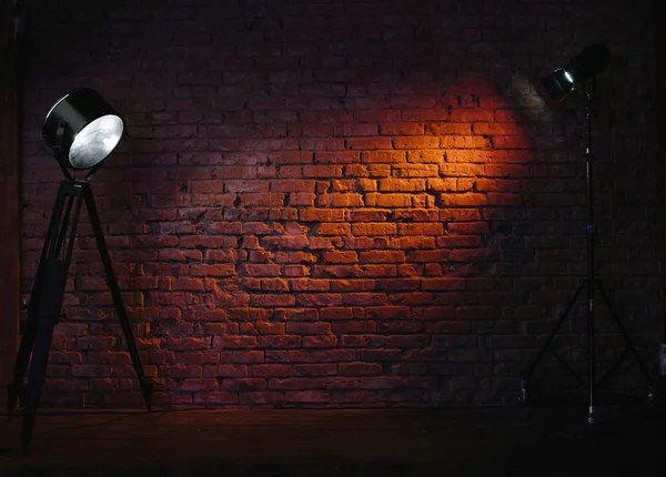 Antiguo muro de ladrillo rojo retro iluminado por una bombilla de escenario. Modificador de luz constante proyectando luz sobre él — Foto de Stock