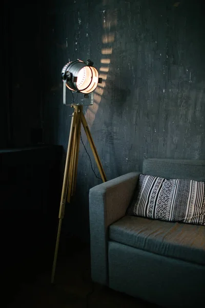 Sofa in dark room interior lit by light equipment — Stock Photo, Image