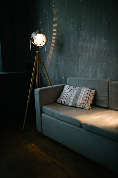 Диван в темной комнате интерьер освещается светлым оборудованием
