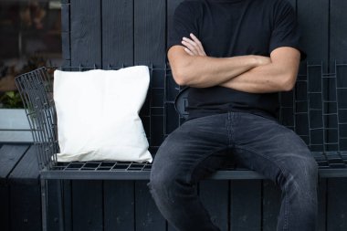 Kentsel şehir arka plan karşı beyaz tekstil eko çanta tutan genç adam. Ekoloji veya çevre koruma kavramı. Sahte için beyaz eko çanta.