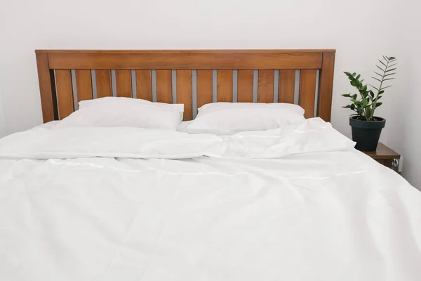 Bedroom with bed and white linens in white room — Stock Photo, Image