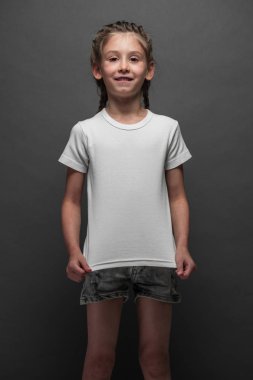 Logonuz için yer veya gri arka plan üzerinde tasarım ile beyaz t-shirt giyen çocuk kız