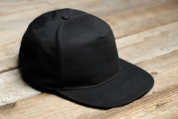 Μαύρο καπέλο μπέιζμπολ για την ψεύτικη ή το λογότυπό σας πάνω από ξύλινο φόντο — Φωτογραφία Αρχείου
