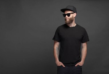 Logo veya tasarım için alan ile siyah boş t-shirt giyen sakallı Hipster yakışıklı erkek modeli
