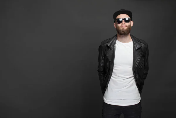 Hipster handsome male model with beard wearing white blank t-shirt and a baseball cap with space for your logo or design in casual urban style — Stock Photo, Image