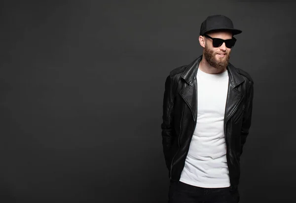 Hipster handsome male model with beard wearing white blank t-shirt and a baseball cap with space for your logo or design in casual urban style — Stock Photo, Image