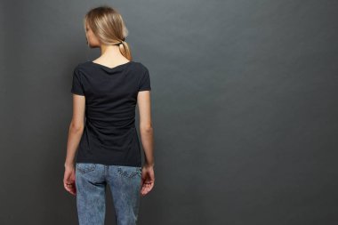 Seksi kadın veya kız logosu için alan ile siyah boş t-shirt giyen, gri arka plan üzerinde rahat kentsel tarzda alay veya tasarım