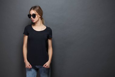 Seksi kadın veya kız logosu için alan ile siyah boş t-shirt giyen, gri arka plan üzerinde rahat kentsel tarzda alay veya tasarım