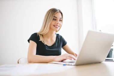 Bilgisayarında çalışan oldukça iş serbest çalışan kadın. Çalışma alanında bir kız. Başlangıç ofis arka planı