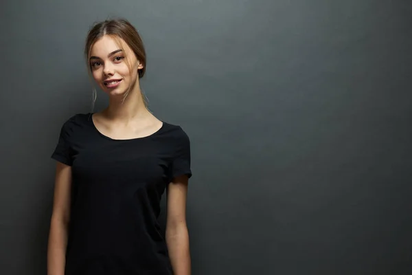 Seksowna kobieta lub Dziewczyna nosi czarny pusty t-shirt z miejscem na logo, makiety lub projektowania w stylu miejskim casual na szarym tle — Zdjęcie stockowe