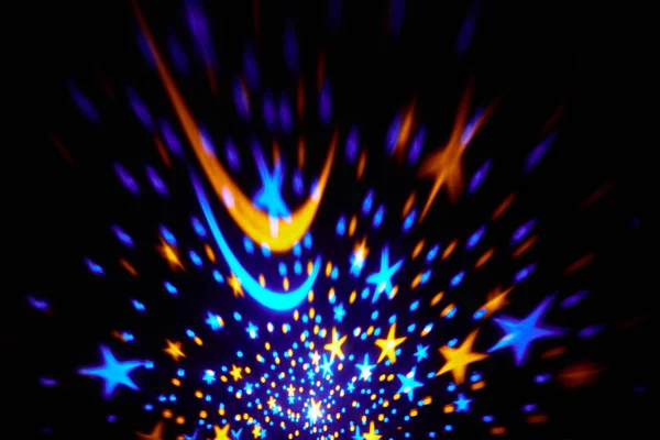 Christmas stars turning in the dark. Colorful stars shining bright in the darkness. Christmas background — Stock Photo, Image
