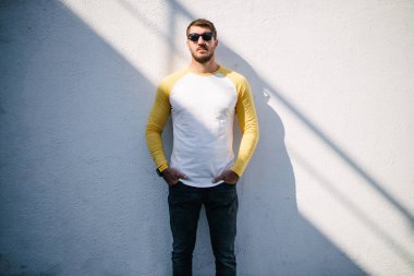 Sakallı, beyaz, boş tişörtlü, beysbol şapkalı, logonuz için yeri olan yakışıklı bir hippi mankeni.