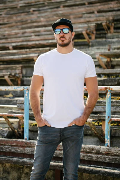 Hipster jóképű férfi modell szakáll visel fehér üres póló és egy baseball sapka helyet a logó vagy design alkalmi városi stílusban — Stock Fotó
