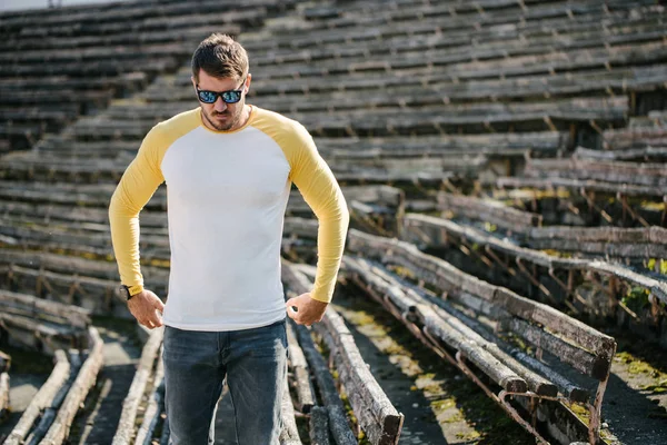 Hipster handsome male model with beard wearing white blank t-shirt and a baseball cap with space for your logo or design in casual urban style — Stock Photo, Image