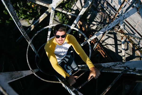 Portrait of a Hipster man with the beard close up climbing a metal ladder — Stock Photo, Image