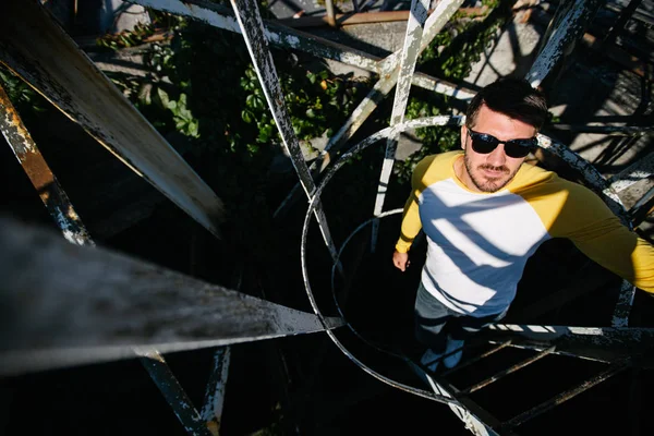 Portrait of a Hipster man with the beard close up climbing a metal ladder — Stock Photo, Image