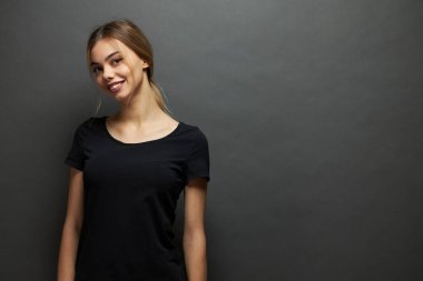 Seksi kadın veya kız logosu için alan ile siyah boş t-shirt giyen, gri arka plan üzerinde rahat kentsel tarzda alay veya tasarım