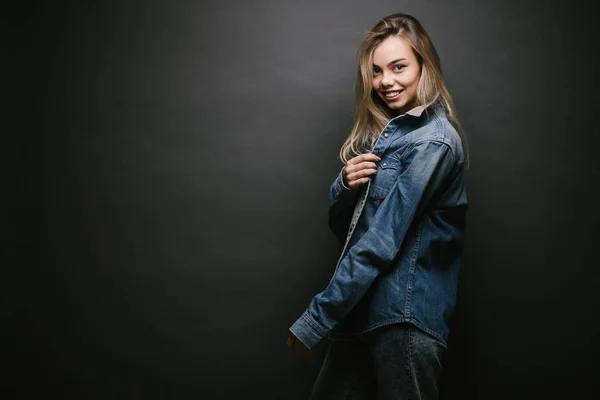 Retrato de moda de una mujer rubia sexy con un maquillaje usando ropa vaquera sobre fondo gris —  Fotos de Stock