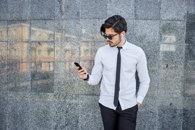 Yakışıklı iş adamı bir telefon görüşmesi yapıyor ya da dışarıda telefon kullanıyor.