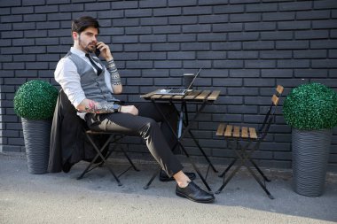 Yakışıklı iş adamı bir telefon görüşmesi yapıyor ya da dışarıda telefon kullanıyor.