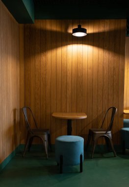 Lambanın altında sandalyeler olan kahve masası.