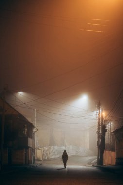 Sisli şehirde gece yalnız yürüyen bir kadın.