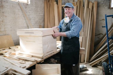 Marangozluk atölyesinde poz veren marangoz.