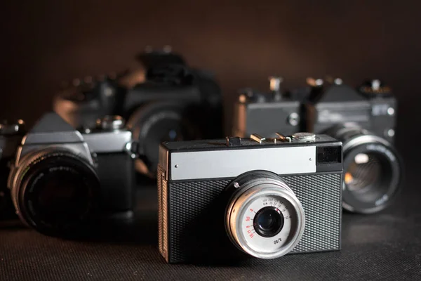 Karanlık arka planda eski model SLR kameralar ve sıcak ışık